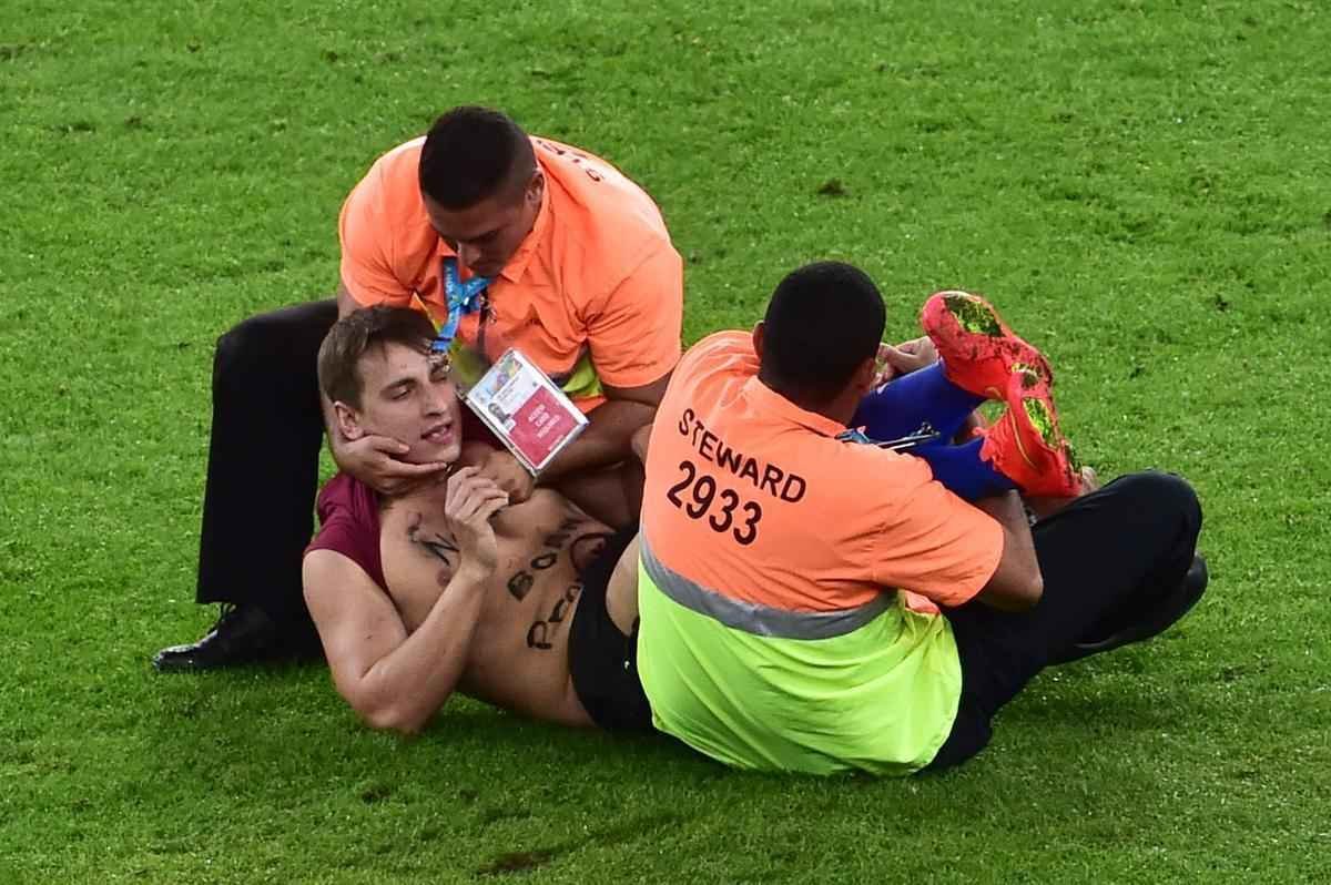 Com dizeres 'brincalho por natureza' na barriga, torcedor invade gramado do Maracan durante a final da Copa do Mundo, entre Alemanha e Argentina, e d trabalho  segurana at ser retirado 