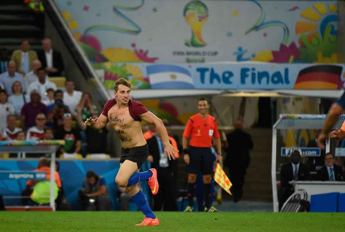 Com dizeres 'brincalho por natureza' na barriga, torcedor invade gramado do Maracan durante a final da Copa do Mundo, entre Alemanha e Argentina, e d trabalho  segurana at ser retirado 