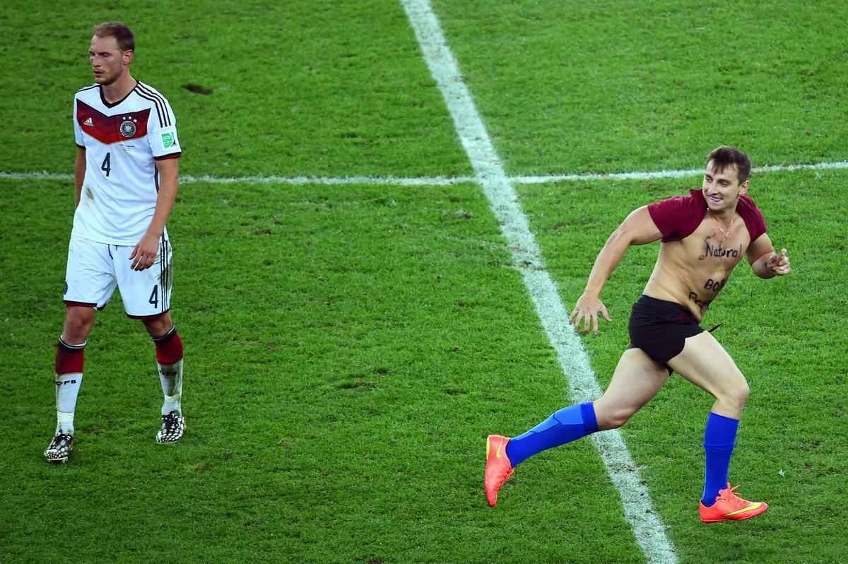 Com dizeres 'brincalho por natureza' na barriga, torcedor invade gramado do Maracan durante a final da Copa do Mundo, entre Alemanha e Argentina, e d trabalho  segurana at ser retirado 