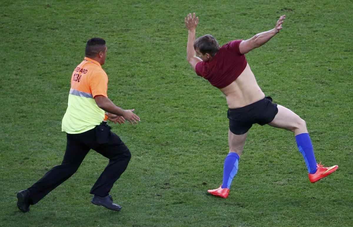Com dizeres 'brincalho por natureza' na barriga, torcedor invade gramado do Maracan durante a final da Copa do Mundo, entre Alemanha e Argentina, e d trabalho  segurana at ser retirado 