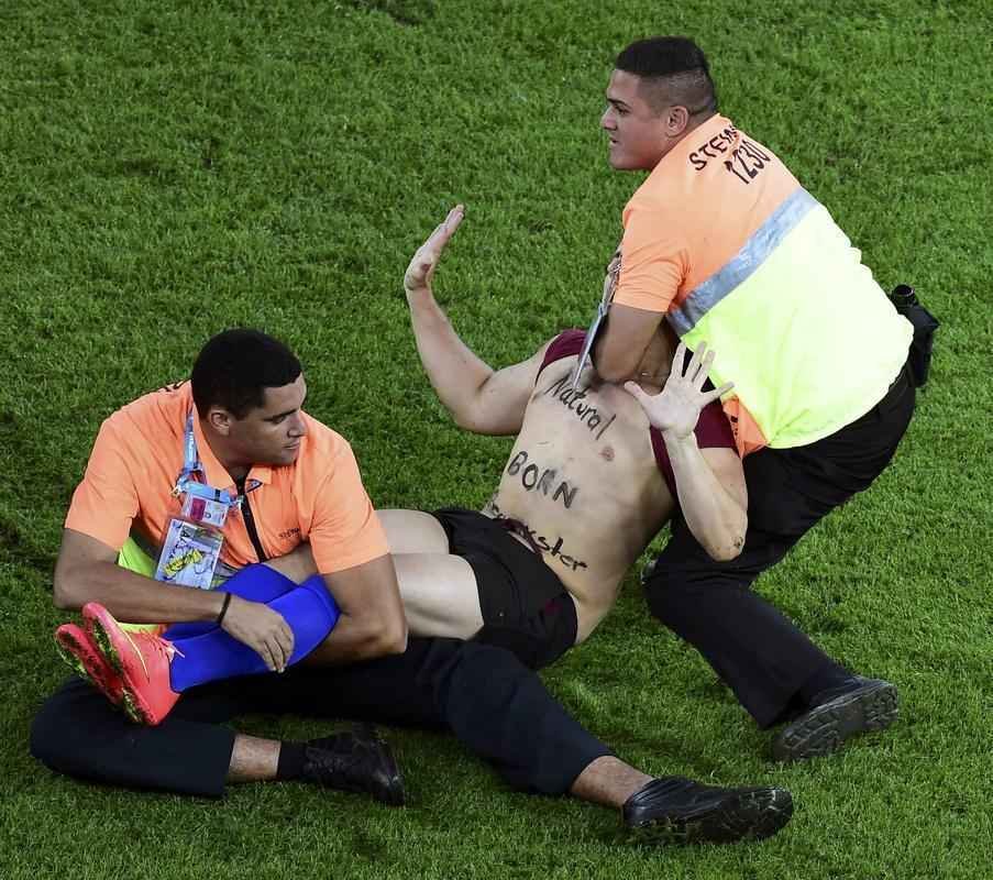 Com dizeres 'brincalho por natureza' na barriga, torcedor invade gramado do Maracan durante a final da Copa do Mundo, entre Alemanha e Argentina, e d trabalho  segurana at ser retirado 