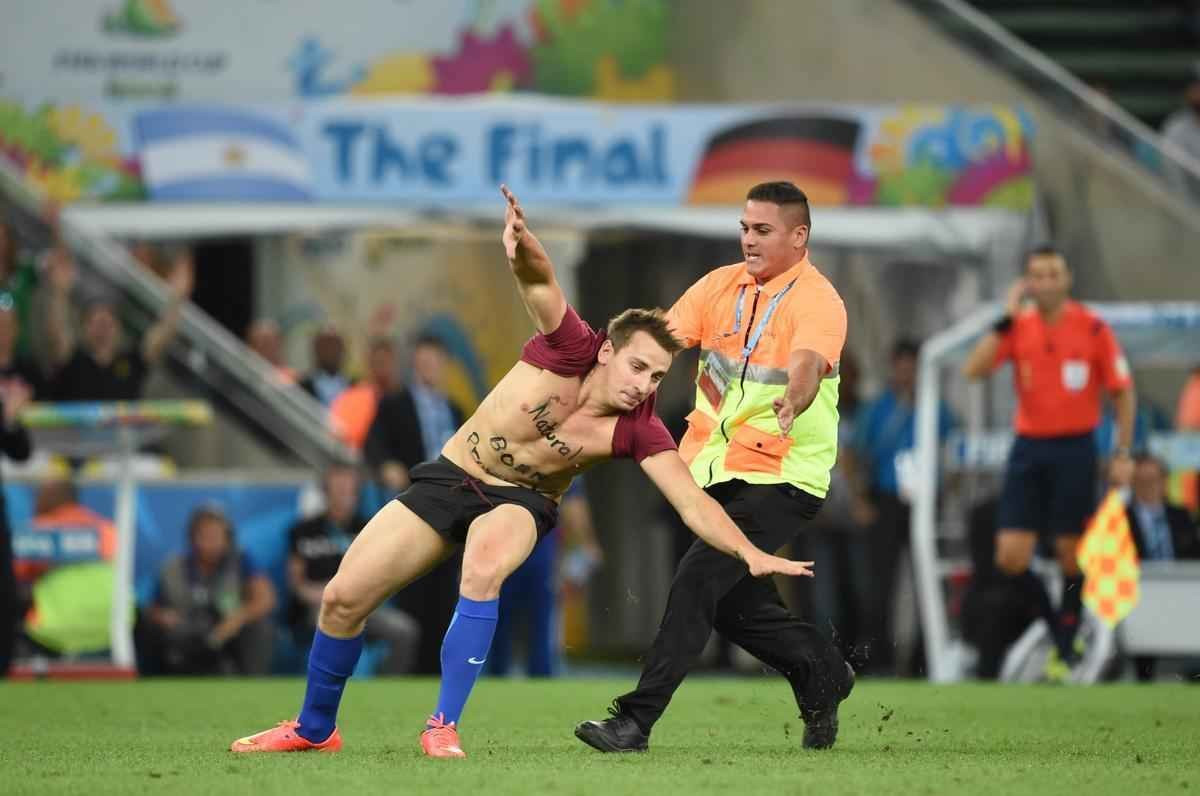 Com dizeres 'brincalho por natureza' na barriga, torcedor invade gramado do Maracan durante a final da Copa do Mundo, entre Alemanha e Argentina, e d trabalho  segurana at ser retirado 