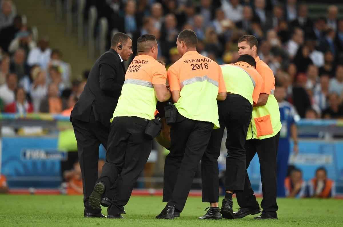 Com dizeres 'brincalho por natureza' na barriga, torcedor invade gramado do Maracan durante a final da Copa do Mundo, entre Alemanha e Argentina, e d trabalho  segurana at ser retirado 